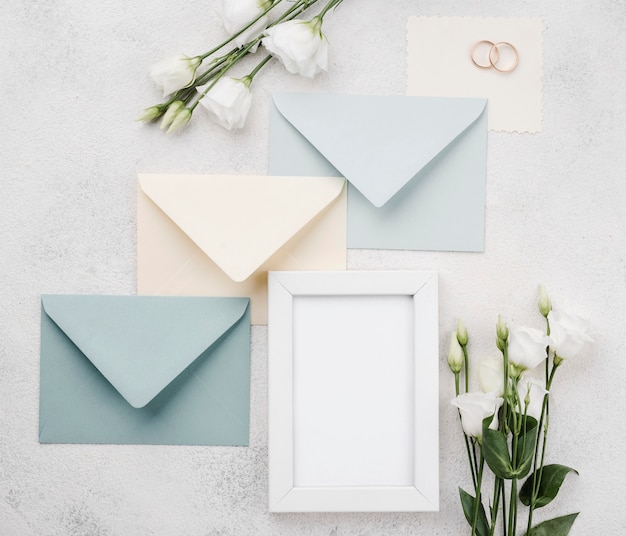 Photo gratuite enveloppes et cadre de mariage vue de dessus