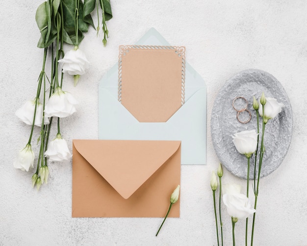 Photo gratuite enveloppes et fleurs de mariage vue de dessus