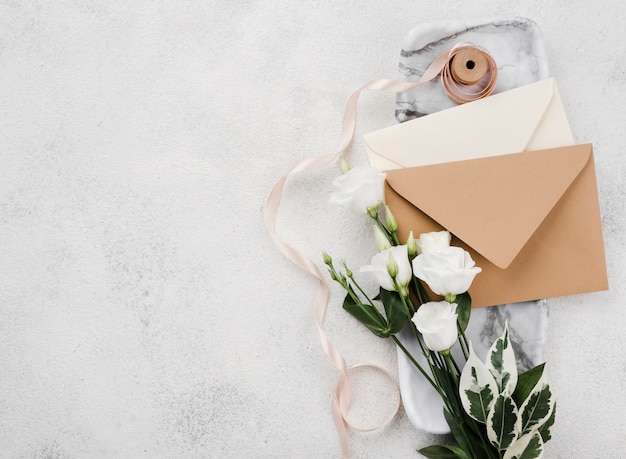 Enveloppes d'invitation de mariage vue de dessus avec des fleurs