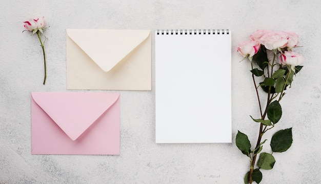 Enveloppes d'invitation de mariage vue de dessus avec des fleurs