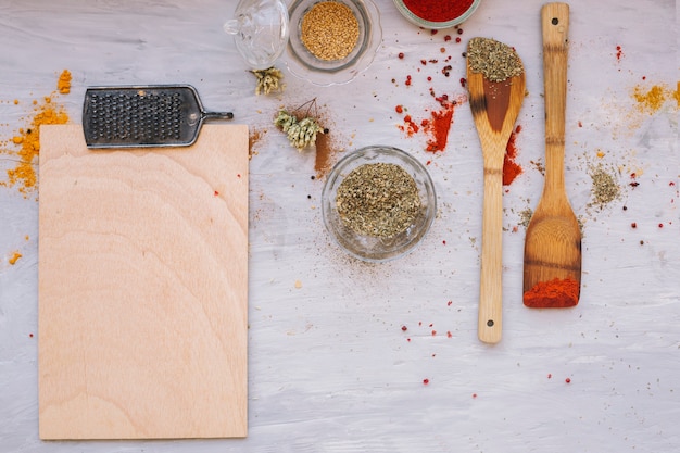 Photo gratuite Épices près des spatules et de la planche à découper