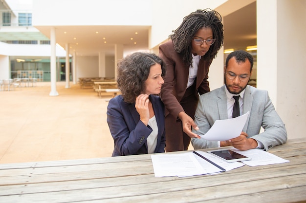 Photo gratuite Équipe commerciale de trois documents à l'étude