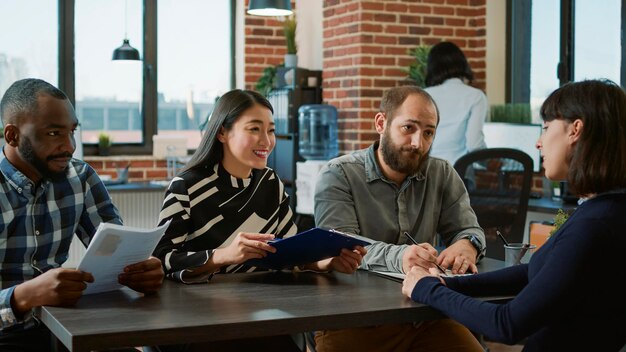 Une équipe diversifiée de travailleurs des RH interrogeant un candidat pour une offre d'emploi, assistant à une réunion d'emploi et de recrutement au bureau. Des hommes d'affaires parlent à une femme sans emploi d'opportunités de carrière.