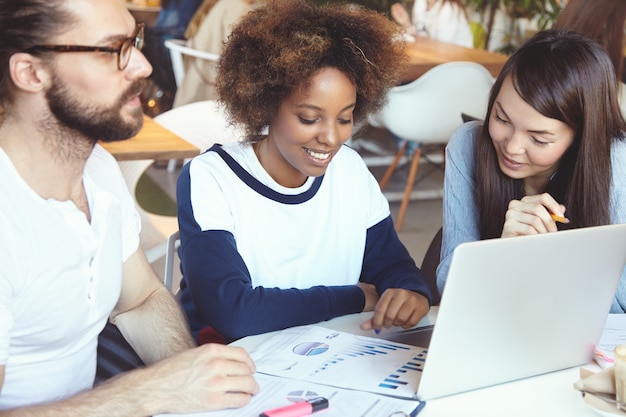 Photo gratuite Équipe de jeunes collègues ayant une réunion au café