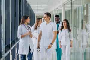 Photo gratuite Équipe de jeunes médecins spécialistes debout dans le couloir de l'hôpital