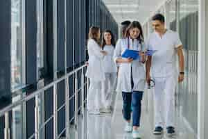 Photo gratuite Équipe de jeunes médecins spécialistes debout dans le couloir de l'hôpital