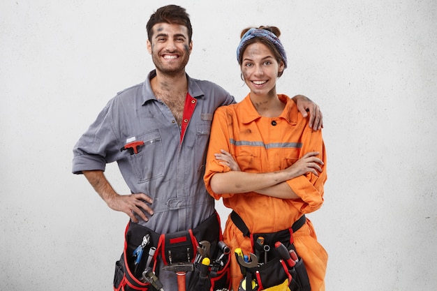 Une équipe souriante de techniciens se tient ensemble, heureux