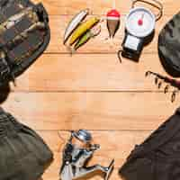 Photo gratuite Équipement de pêche et vêtements pour hommes sur une planche en bois