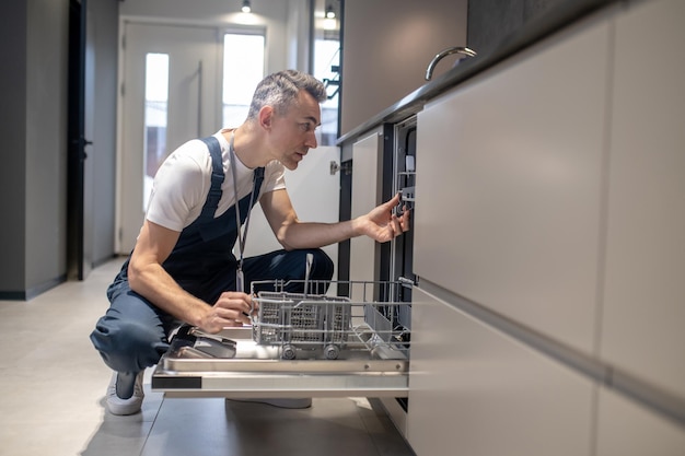 Photo gratuite Équipements de cuisine profil de l'homme touchant des détails dans la cuisine éclairée par la lumière du jour