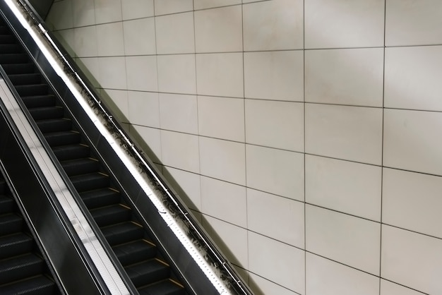 Escalator avec mur carrelé blanc