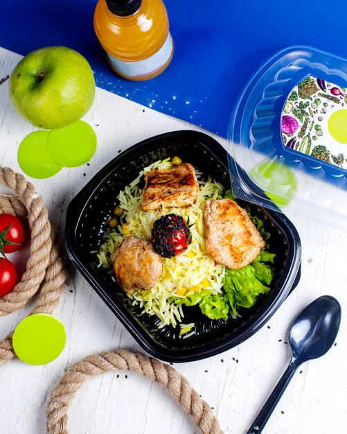 escalope de poulet avec riz et tomate dans la boîte de livraison