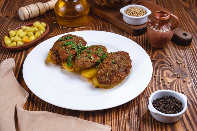 Escalopes de viande avec des épices de pomme de terre verts vue latérale