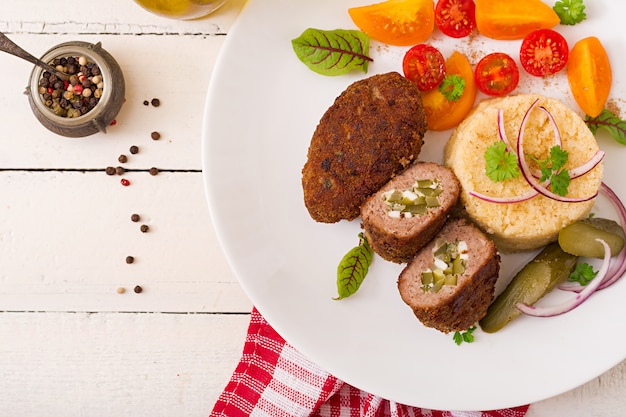 Escalopes de zrazy avec viande hachée avec concombre mariné et oeufs et garniture de boulgour