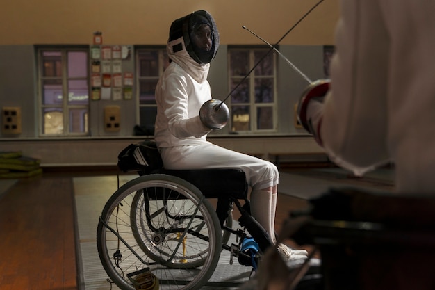 Escrimeur handicapé dans un équipement spécial assis dans un fauteuil roulant