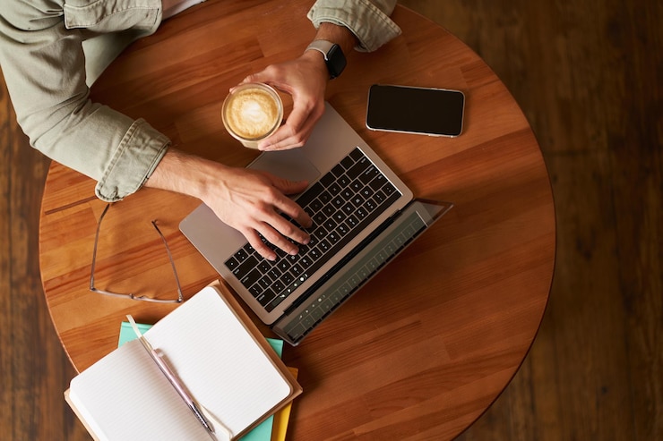 Photo gratuit espace de coworking freelance et concept d'apprentissage électronique vue de haut mains masculines tenant une tasse de café et utilisant
