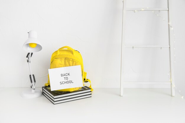 Espace de travail blanc pour élève avec sac à dos jaune