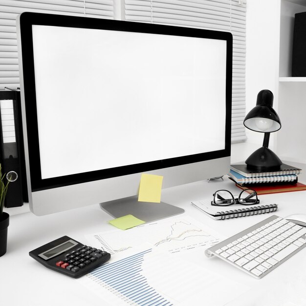 Espace de travail avec écran d'ordinateur et lampe