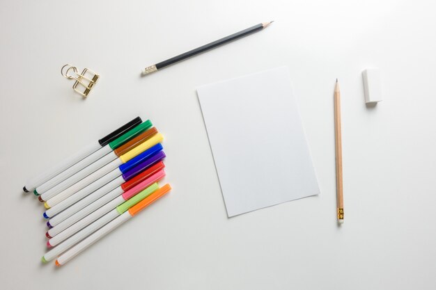 Espace de travail minimal - Photo créative d&#39;une table plate de bureau d&#39;espace de travail avec carnet de croquis et crayon en bois sur fond blanc de copie. Vue de dessus, photographie à plat.