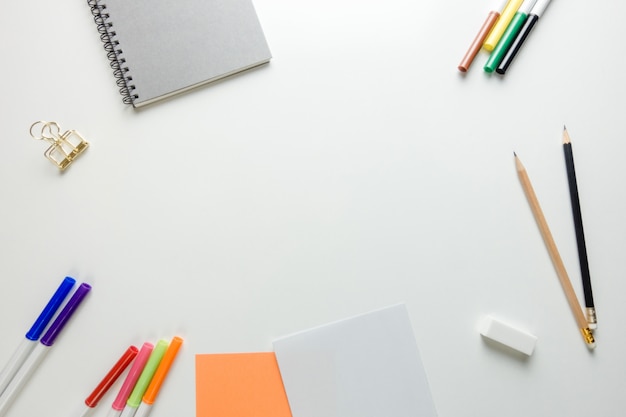 Espace de travail minimal - Photo créative d&#39;une table plate de bureau d&#39;espace de travail avec carnet de croquis et crayon en bois sur fond blanc de copie. Vue de dessus, photographie à plat.