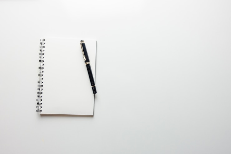 Photo gratuit espace de travail minimal - photo créative de la table plate du bureau de l'espace de travail avec un carnet de croquis et un crayon en bois sur un fond de copie fond blanc. vue de dessus, photographie plate.