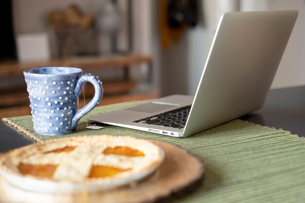 Espace de travail avec ordinateur portable et arrangement de tarte