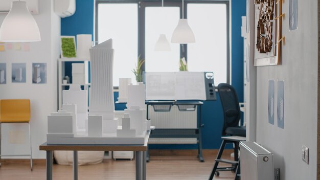 Espace vide avec maquette sur table pour concevoir le plan de propriété urbaine et la disposition du modèle de construction. Personne au bureau avec un projet d'architecture pour le développement immobilier et la présentation.