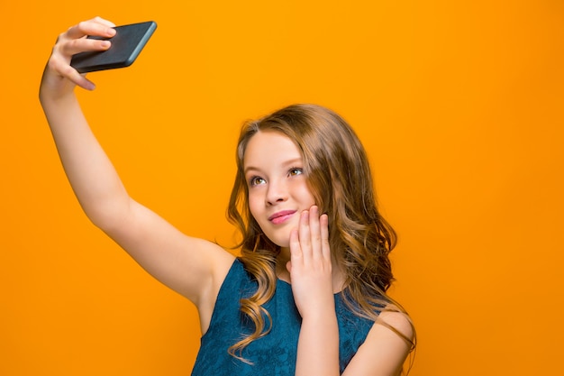 espiègle adolescente heureuse avec téléphone