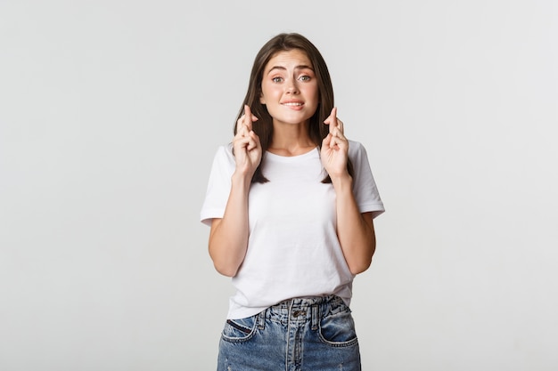 Espoir fille inquiète croise les doigts bonne chance, faisant des vœux et désirant quelque chose.