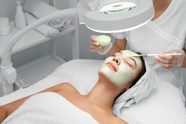 Esthéticienne, appliquer un masque facial sur une cliente