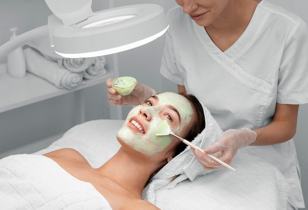 Photo gratuite esthéticienne, appliquer un masque facial sur une cliente