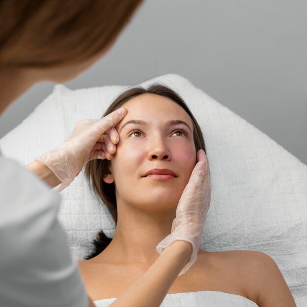 Esthéticienne avec cliente au salon pour la routine de soins du visage