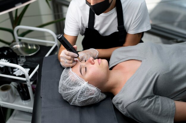 Esthéticienne faisant une procédure de microblading