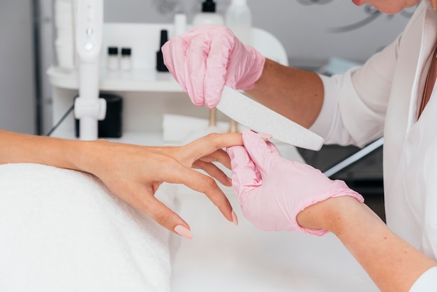 Esthéticienne en hygiène et soins des ongles portant des gants