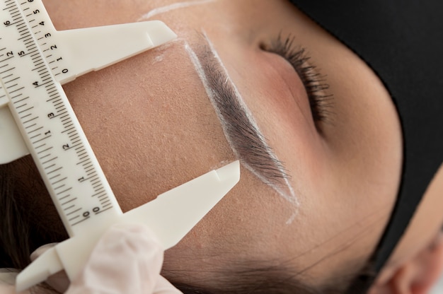 Photo gratuite esthéticienne travaillant sur les sourcils d'un client