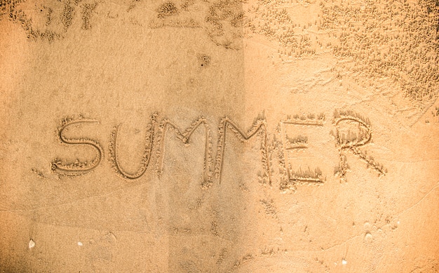 Photo gratuite l'été écrit dans le sable