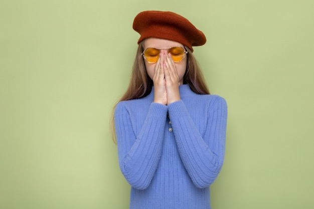 Les éternuements Ont Saisi Le Nez Belle Petite Fille Portant Un Chapeau Avec Des Lunettes Isolées Sur Un Mur Vert Olive