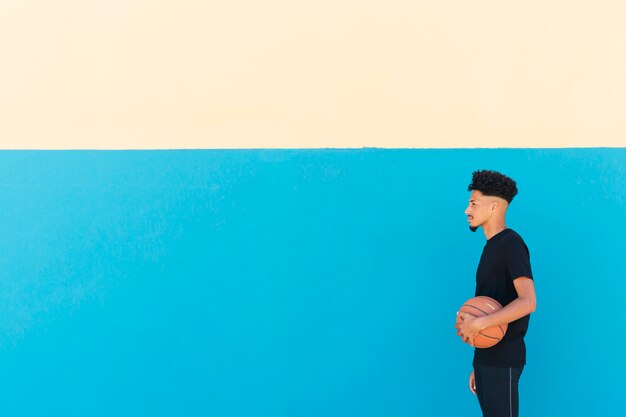 Ethnique sportif avec cheveux bouclés debout avec basket