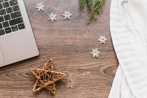 Photo gratuite Étoile en bois avec des flocons de neige sur la table