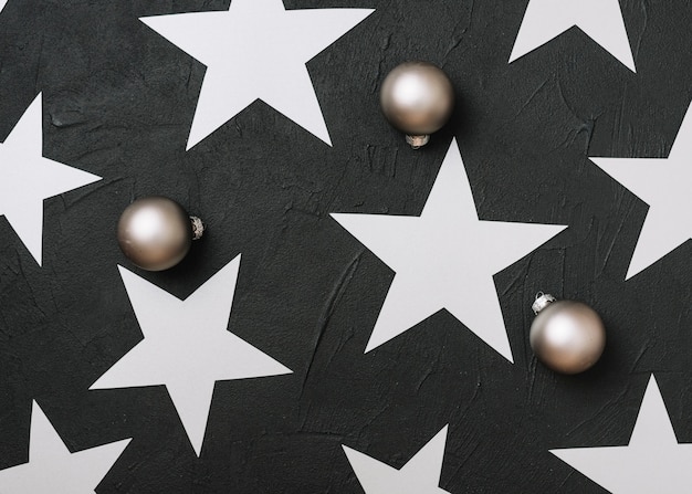 Photo gratuite Étoiles en papier avec des boules brillantes sur la table