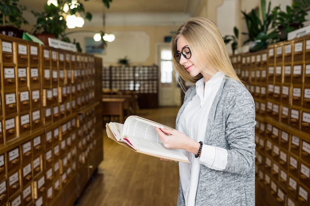 Photo gratuite Étudiant souriant, lire un bon livre