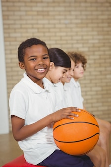 Étudiant tenant le basket-ball avec d'autres joueurs