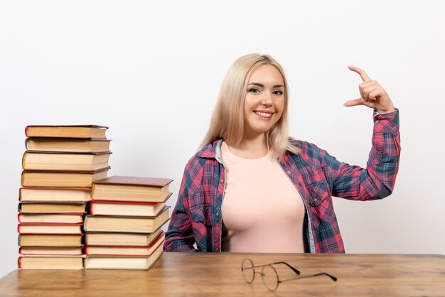 étudiante juste assise avec des livres sur blanc