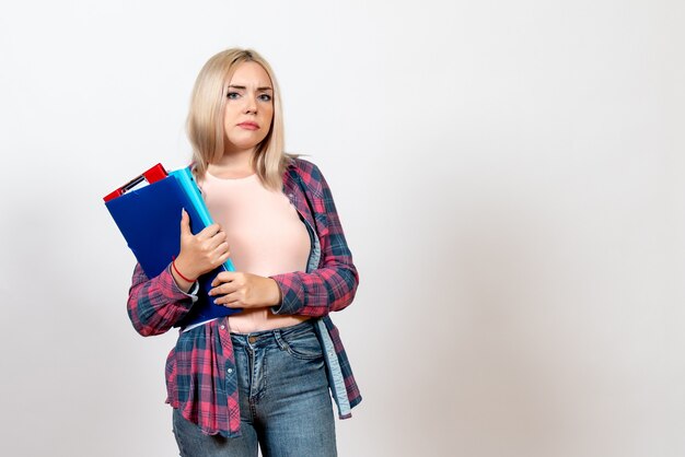 étudiante tenant différents fichiers sur blanc