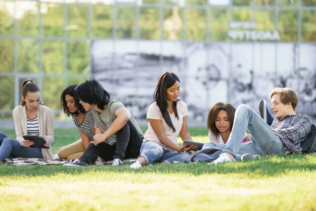 Des étudiants concentrés étudient à l'extérieur.