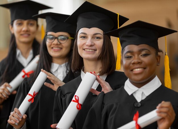 Les étudiants diplômés portant une casquette et une robe coup moyen