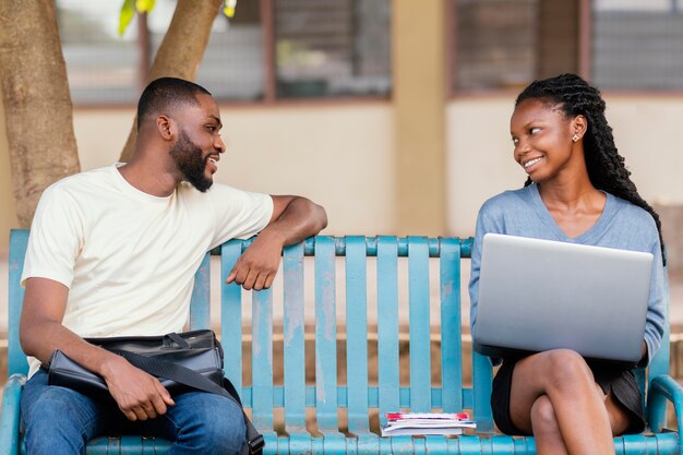 Photo gratuite Étudiants smiley coup moyen sur banc