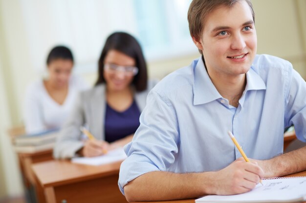 étudiants souriant assis dans la rangée