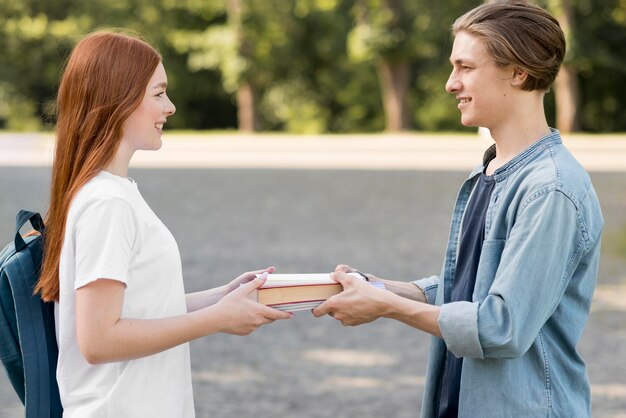 Des étudiants universitaires échangent un livre