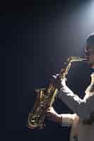 Photo gratuite un européen joue du saxophone dans le noir