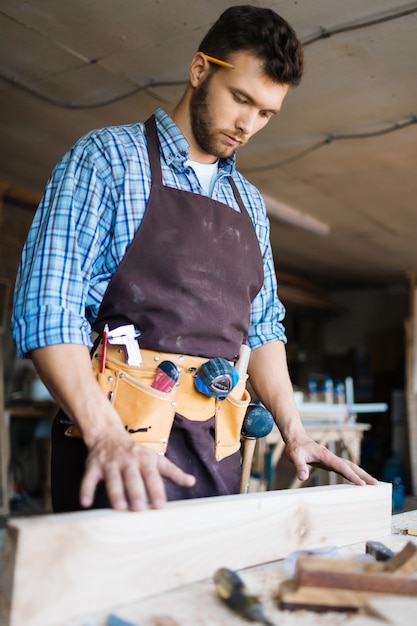 Examiner une planche de bois en atelier